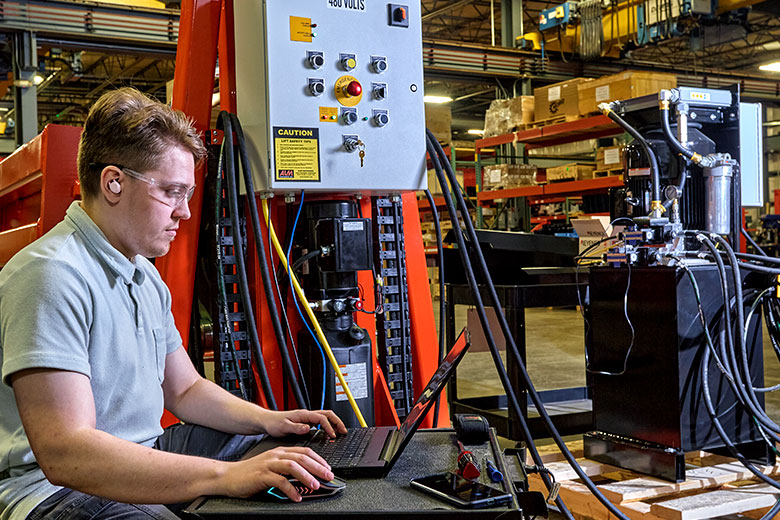 man in safety glasses at laptop